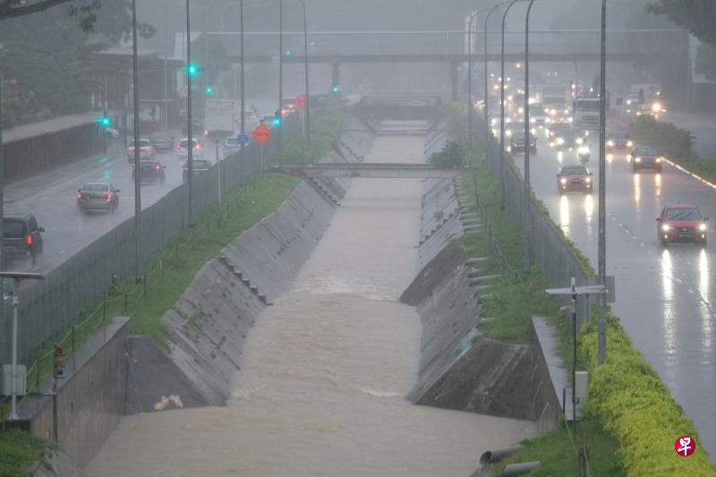 本地昨天清晨下起豪雨，阿尔柏王园地铁站外的沟渠水位一度达到90％，有突发性淹水的风险。上午9时许，武吉知马路和杜尼安路双向行驶车辆因天雨路滑，须打灯缓慢行驶。（曾坤顺摄）