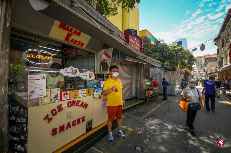 龙伍禄（黄衣者）和两名生意伙伴上月起在牛车水街市开档卖冰淇淋等甜品，每月租金1000多元，租约为期半年。（叶振忠摄）