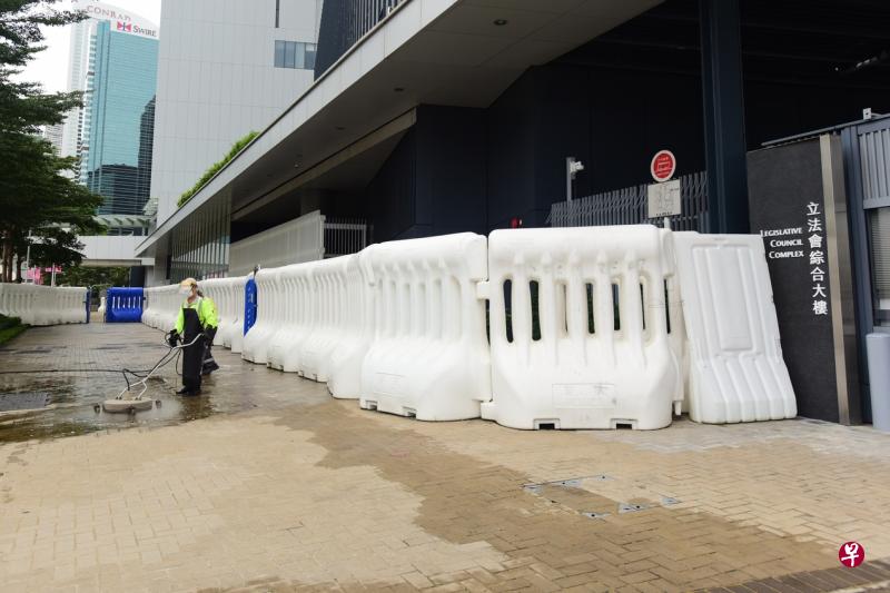 香港立法会大楼外部分的水马已移除，工人在进行清洁工作。（香港中通社）