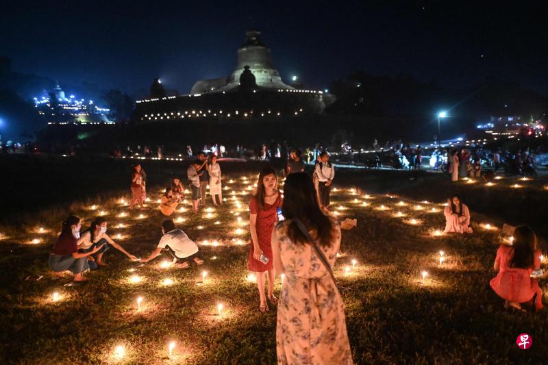 除了攀爬神山，缅甸若开邦民众入夜时分也到妙乌镇（Mrauk-U）的佛塔周围聚集拍照，庆祝传统的点灯节。小图为当地人摸黑尝试爬上“500神鸭山”。（法新社）