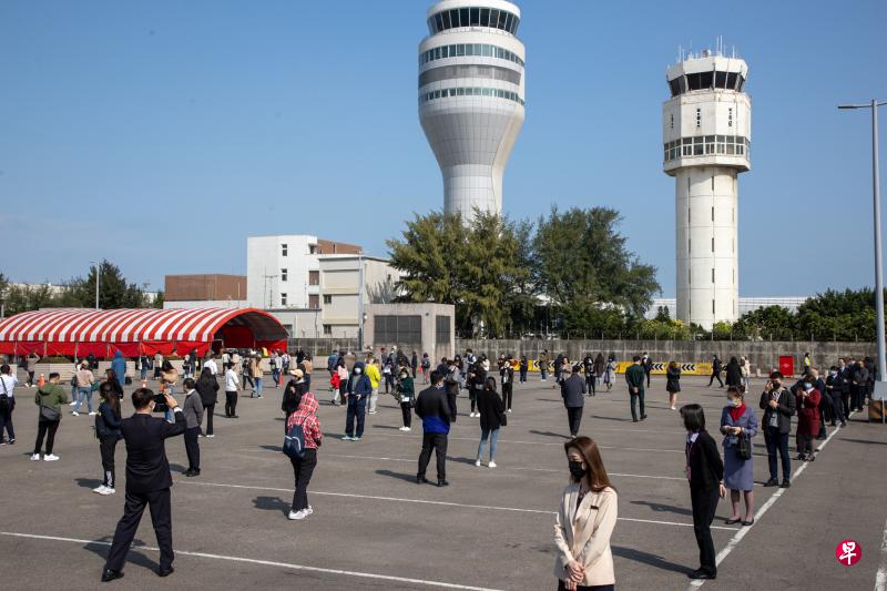 桃园机场面对多条传播链，昨天已全面筛检机场内与旅客接触的第一线人员，紧急设立三处PCR筛检站，目前已有3000余人完成采检，预计采检8000余人。图为桃园机场第一线人员排队等候PCR筛检。 （香港中通社）