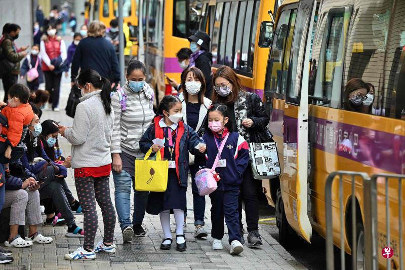 港府昨天宣布全港小学及幼稚园，在本周五或之前暂停面授课堂。图为儿童放学后在家长和外籍女佣陪同下回家。（法新社）