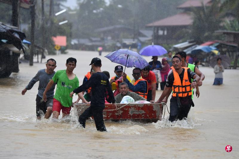 泰南陶公府拉艾县周六豪雨成灾，救援人员出动小艇将低洼地区民众疏散到救灾中心。（法新社）