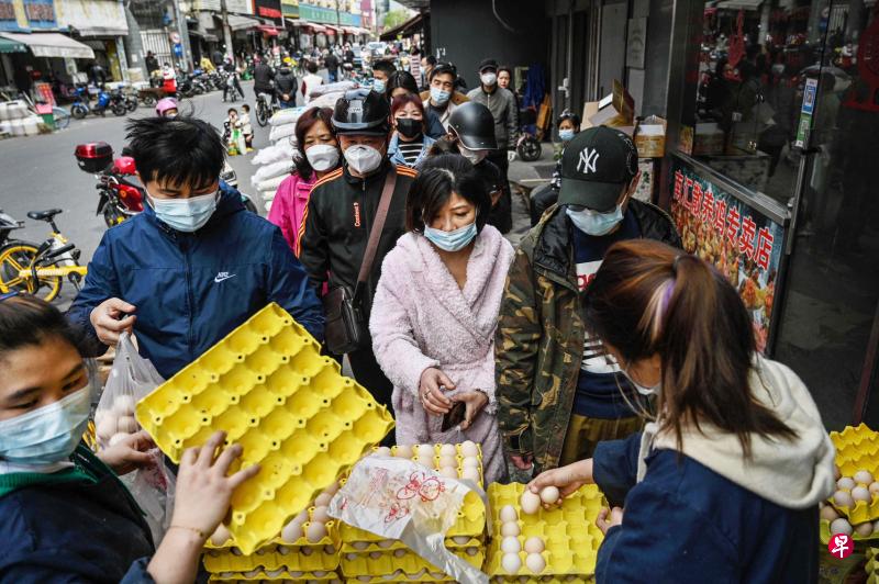 上海市政府前天宣布分区封控措施后，不少民众开始抢购食物等生活物资。图为上海市杨浦区的民众在一处商场前排队抢购鸡蛋。 （法新社）