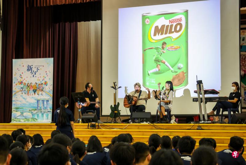 弹唱人“新声代”歌手向军港中学学生介绍本地咖啡店的特殊用词。（叶振忠摄）