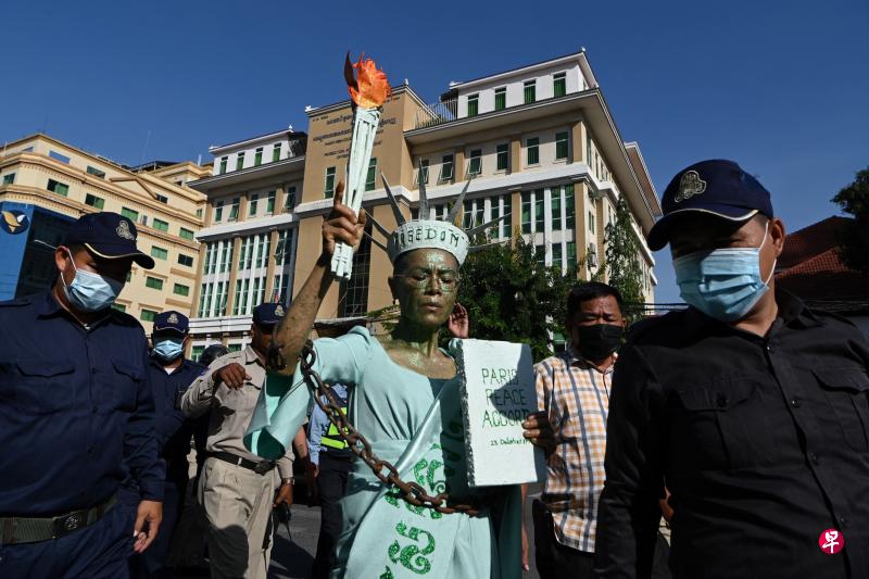 柬裔美籍人权律师陈昇昨天装扮成自由女神像出庭。法院判她叛国罪罪成后，现场警员随即把她压上警车带走。（法新社）