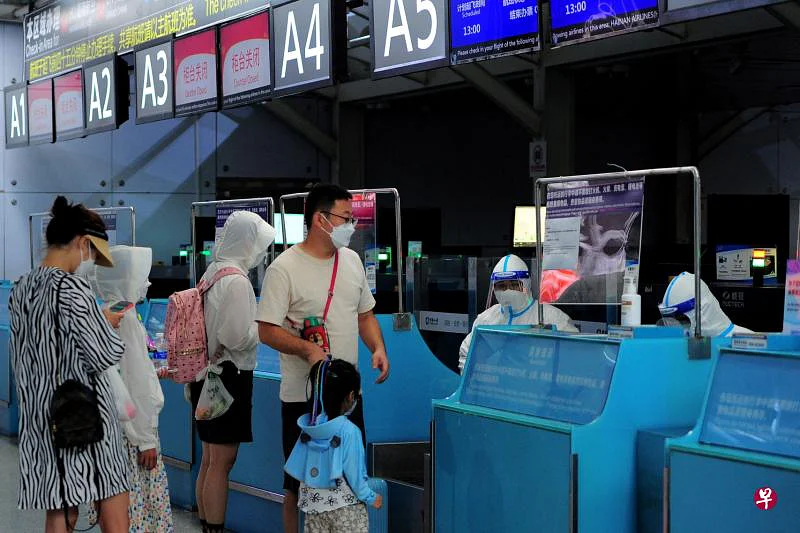 中国海南省政府从8月9日起，让符合条件的滞留旅客陆续返程，图为受困游客当天在三亚凤凰国际机场办理登机手续。此外，海南海口市从13日起，全面恢复机场客运航班常态化运行，旅客在满足条件后可离岛。但据财新网报道，多名旅客反映，海口机场出港航班数量稀少，离岛仍有困难。（法新社）