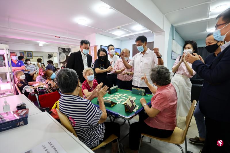 太和观慈善机构星期五（8月19日）在位于庙弯的活跃乐龄站，与护联中心、乐龄辅导中心，以及曹氏基金会签署谅解备忘录，也与新加坡中央医院签署合作协议。卫生部长王乙康（右四，白衣）到场见证签署仪式，也与在乐龄站娱乐的年长者玩游戏。（陈渊庄摄）