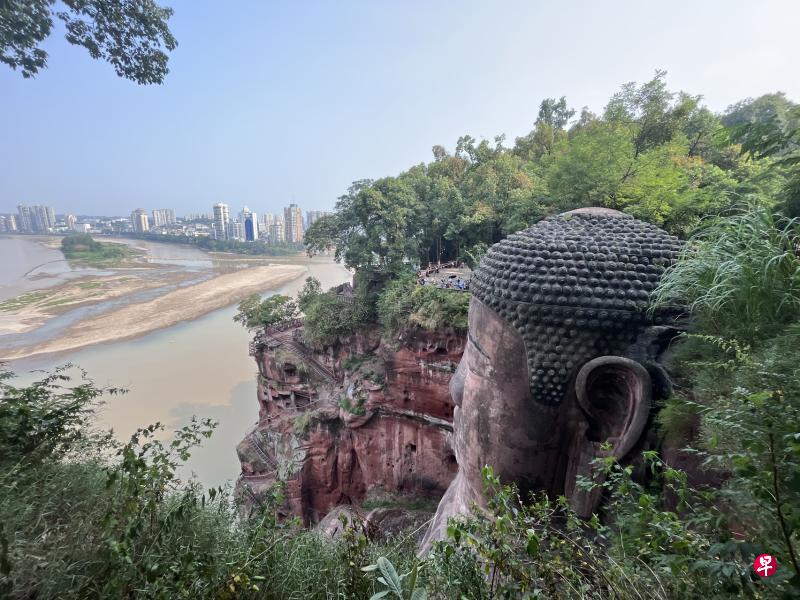 受持续高温、降水偏少影响，四川省乐山市的大渡河、青衣江和岷江水流量明显减少，位于三江交汇处的乐山大佛，眼底下江流滚滚的景观不再，甚至露出部分河床。（中新社）