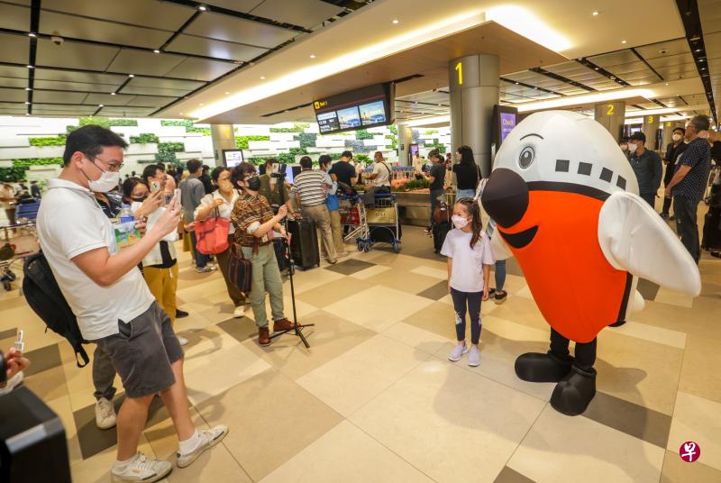 樟宜机场第四搭客大厦重开首日，樟宜机场集团特别为乘客准备礼品、邀请乐队为乘客献唱，还请了吉祥物“Max”到场和乘客拍照留念。（ 叶振忠摄）