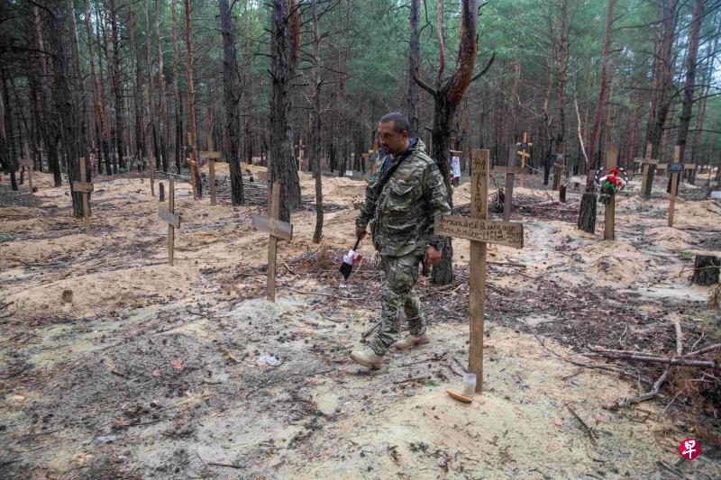 在乌克兰哈尔科夫地区，当局在近日收复的城镇伊久姆附近发现一个乱葬岗，死者多数是身份不明的平民。（路透社）