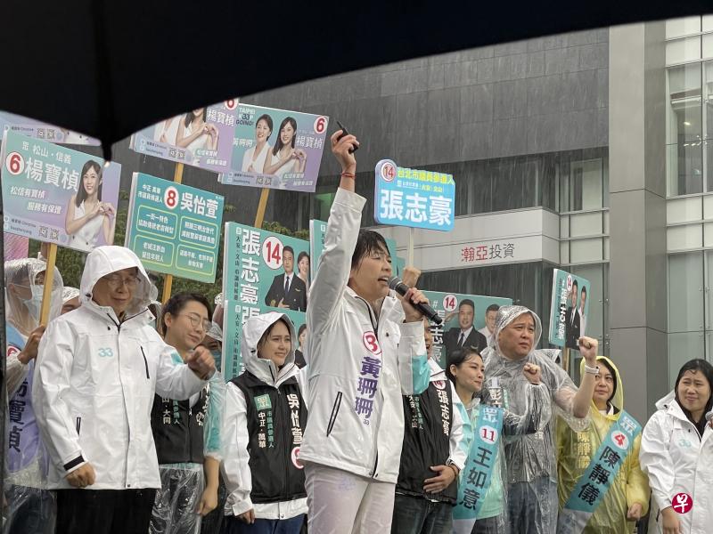 亲民党出身的黄珊珊（中）上星期日（10月30日）在台风外围环流带来的风雨中举行首场大型造势活动，眼睛被大雨打到几乎睁不开，但年轻支持者热情激昂。（庄慧良摄）