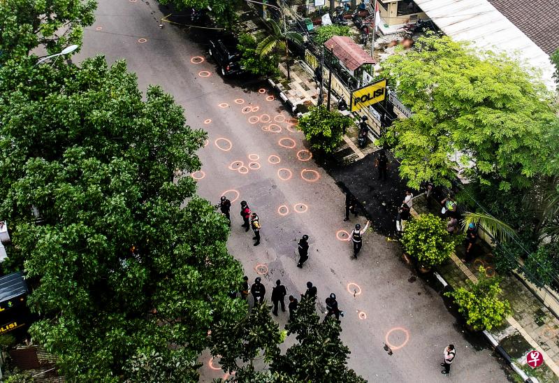 爆炸发生后，警方封锁了被炸警局所在的街道。调查人员抵达后，将地上的证物圈起做详细记录。（路透社）