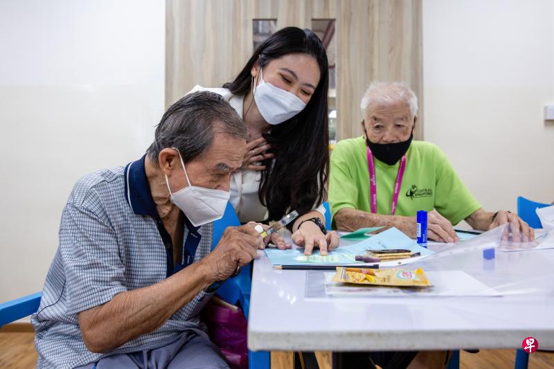 助理心理治疗师郑诗凌（中）协助参与盛港综合医院“精神健康计划”的老人，完成有关“健康思维模式”的作业。（盛港综合医院提供）