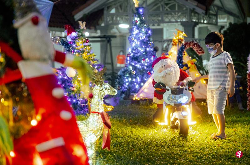 位于勿洛的一块草坪上，不仅有圣诞树、驯鹿、圣诞袜子等装饰，更有圣诞老人骑着电单车，似乎在迎接到访的居民们。看着眼前的景象，小男孩仿佛置身童话世界，流连忘返。（李冠卫摄）