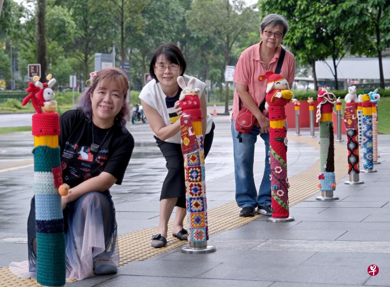 Yarn Bombing的胡珍珍（左起）、陈雅凤和谢丽清和30多名会员一针一线钩织出兔年作品，为防撞柱添上一抹亮色。（曾坤顺摄）