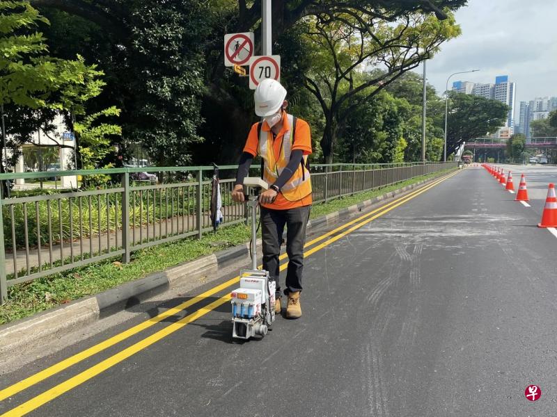 陆交局在西海岸大道试用新的铺路材料，工作人员使用仪器测量道路的粗糙度。（陆交局提供）