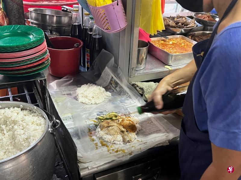 芳记的鸡饭好吃，用报纸包饭也令人印象深刻。（叶孝忠摄）