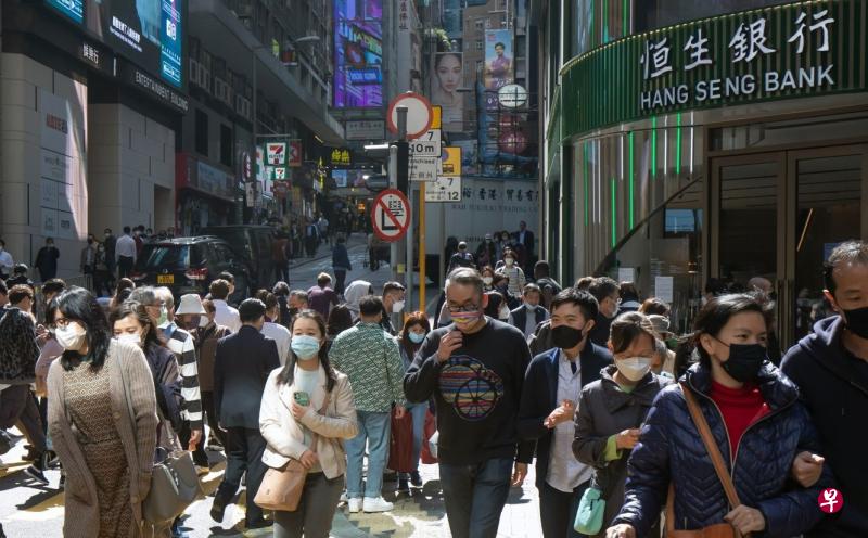 香港特首李家超星期二宣布，星期三起全面撤销口罩令，结束了香港长达945天强制戴口罩的日子。图为星期二行走在港岛中环地区的人群，人人都佩戴口罩。（彭博社）