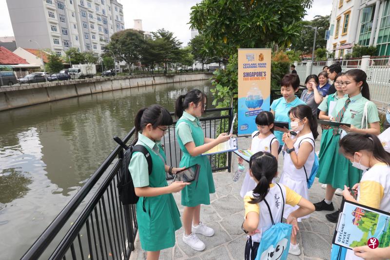 傅海燕（身着浅蓝衬衫者）陪同约30名光华学校学生到芽笼河踏上由丹绒加东女校学生设计的学习之旅，了解我国水域保护和河流历史。（唐家鸿摄）