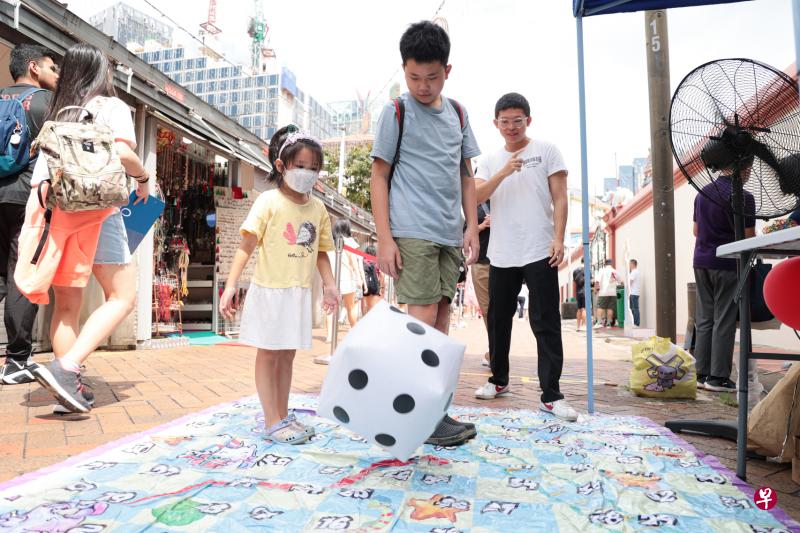 配合牛车水五脚基节，宝塔街上出现了各种怀旧游戏，例如骰子棋。对小朋友来说，这些游戏很陌生，却又很新奇有趣。（李冠卫摄）