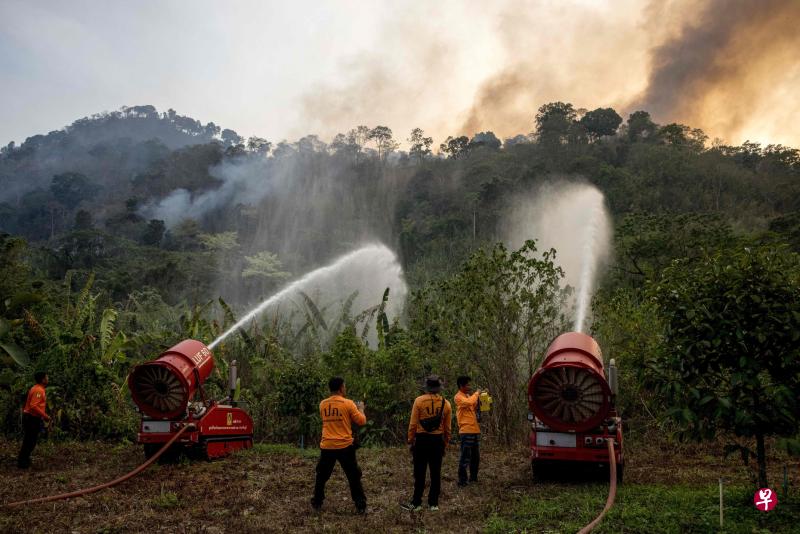 旱季容易引发林火，导致泰国多个地区的空气污染指数都超标。图为消防员3月31日在中部那空那育府的一座山边尝试扑灭林火。（法新社）