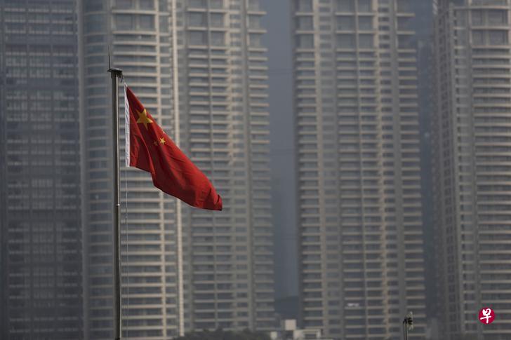 A Chinese flag is seen in front of the financial district of Pudong in Shanghai, China, January 19, 2016. China's development push into poor countries is marginalizing the role of human rights bodies, green groups and other non-profits, making it harder for them to play their traditional role as a check on rampant development, advocates said. FILE PHOTO: REUTERS