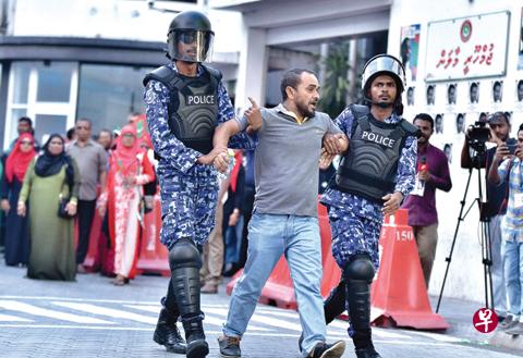 Maldivian police arrest a man at a protest appealing for the release of opposition leaders held in jail in the Maldives capital Male. Maldives President Abdulla Yameen is embroiled in a bitter power struggle with his opposition that has plunged the Maldives, a popular holiday destination, into crisis. PHOTO:AFP