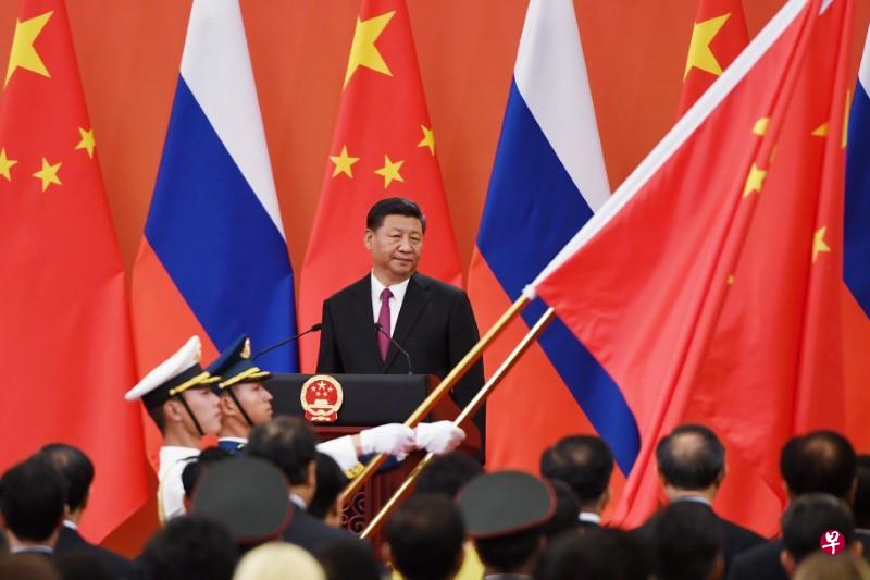 Chinese President Xi Jinping (C) looks on as Chinese soldiers carry the Chinese flag during a medal presentation ceremony in the Great Hall of the People in Beijing, China June 8, 2018. PHOTO: REUTERS