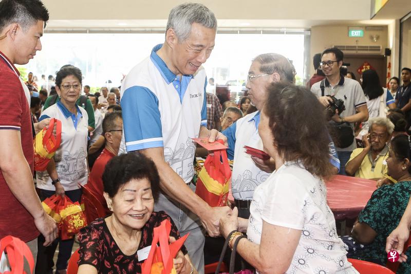 李显龙总理星期天在宏茂桥德义区给居民拜早年。（梁伟康摄）