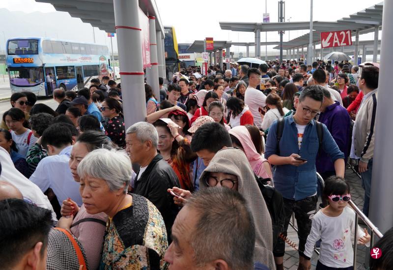  农历大年初二，经港珠澳大桥抵达香港口岸的众多大陆游客在巴士站候车，准备前往香港市区。（中新社）