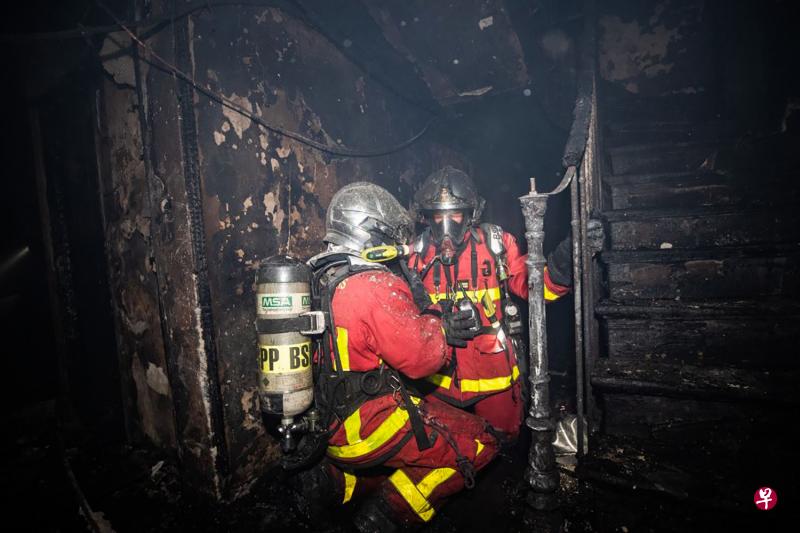 2019年6月22日，巴黎内穆尔街的一栋六层高的楼房失火，消防员在建筑物内执勤。（法新社） 