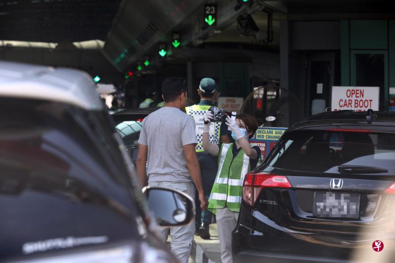 移民与关卡局在兀兰关卡对所有旅客进行体温检测。（档案照）