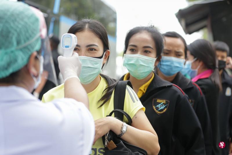 泰国冠病疫情严重，各省份的边境都设有检查站，人们必须检查体温后才能通过。（法新社） 