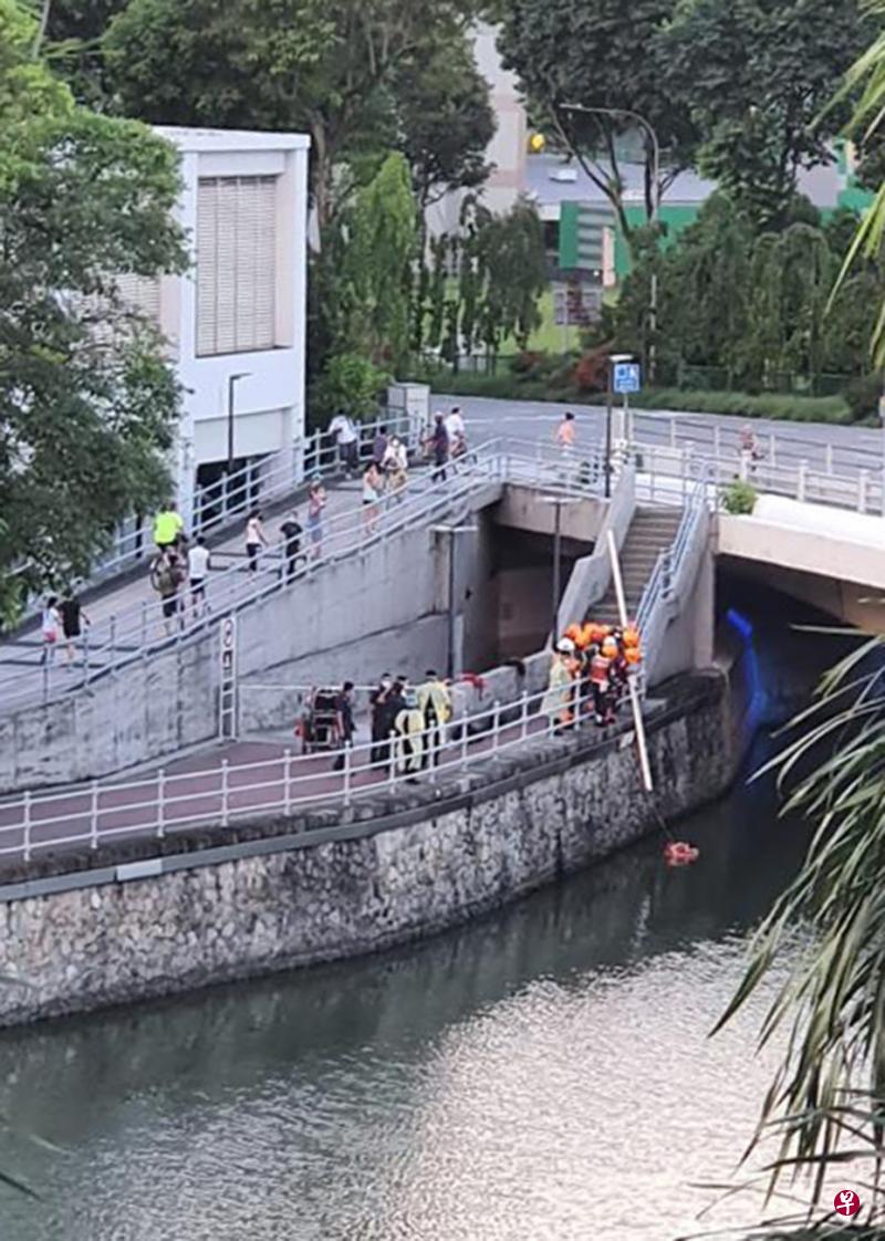 女子坠入河中后，有公众马上将救生圈丢入河中给女子，民防部队随后到场，并用梯级将她救上来。（受访者提供） 