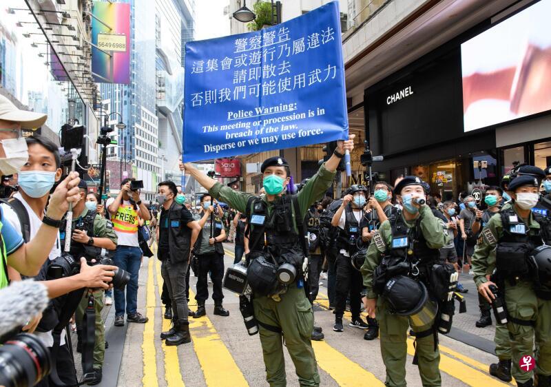 防暴警在铜锣湾展示蓝旗，警告在场人士正参与非法集结，要求他们离开。（法新社）