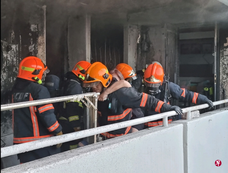 民防人员从失火单位隔壁的单位救出住户。（取自新加坡民防部队面簿） 