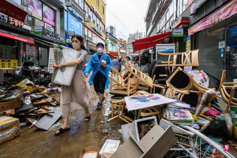 在首尔江南区历史悠久的南城市场，商店外堆满被雨水摧毁的杂物，场面一片狼藉。（法新社） 