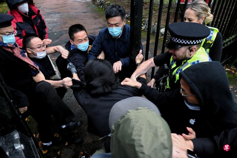 在英国曼彻斯特，一名男子16日在反对中国国家主席习近平的示威活动后被拉到中国领事馆门口。（路透社）
 