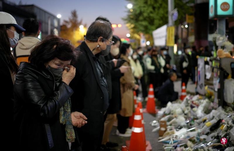 韩国首尔梨泰院踩踏事故造成大量人员伤亡，人们在事发现场附近献花吊唁遇难者。（路透社） 