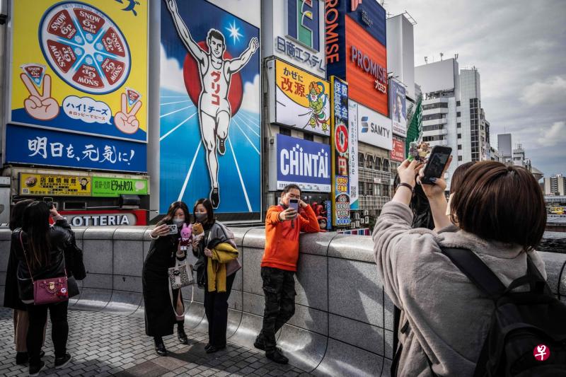 最新数据显示，日本在11月迎来近100万名入境旅客。图为12月1日，民众在大阪著名的道顿堀商业街留影。（法新社） 