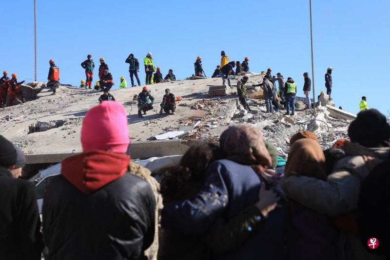 2月9日，在土耳其加济安泰普一处完全坍塌的建筑物上，救援人员正设法救出受困的人，无助的民众只能焦虑地继续等待。（法新社） 