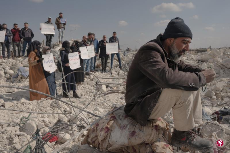 2月12日，数名叙利亚人在阿勒颇省（Aleppo）高举抗议标语，指责联合国未能及时向地震灾区提供救援物资。（纽约时报） 